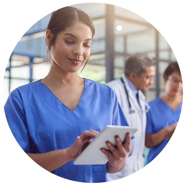 Home Health Software | A clinician typing on a tablet with a doctor and nurse in the background- Netsmart myUnity® home health EHR software for clinical documentation, scheduling, and billing